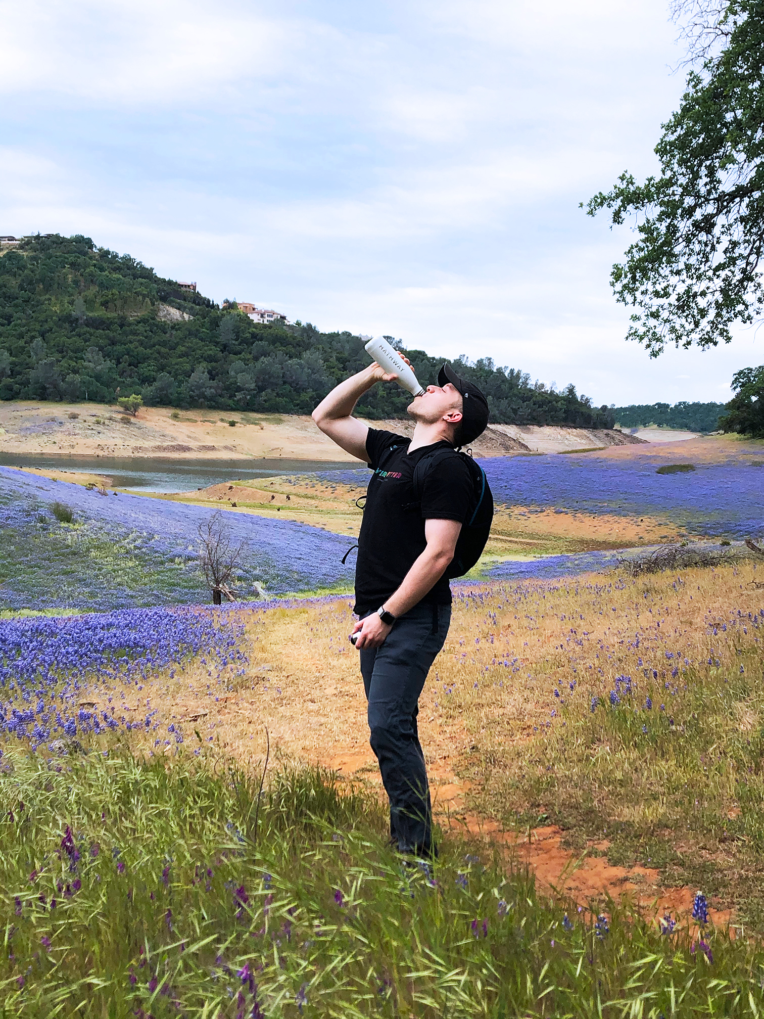 man drinking water on hike