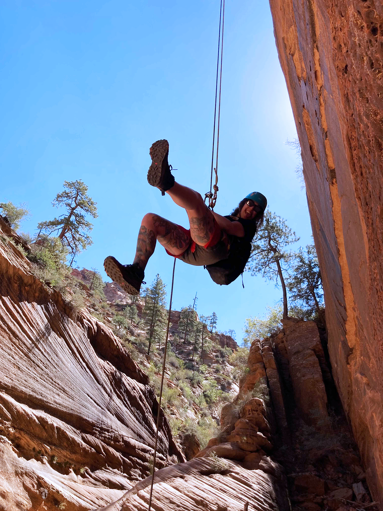 girl climbing big red rocks