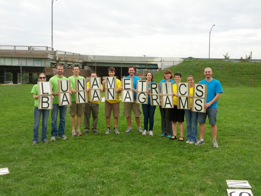 The LunaMetrics team poses with giant bananagrams tiles that spell 'LunaMetrics Bananagrams'